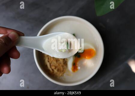 Essen von Reisbrei, Reisbrei oder Congee Stockfoto