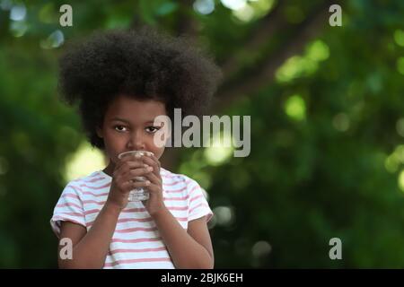 Afroamerikanische Kind Trinkwasser im Freien. Konzept der Wasserknappheit Stockfoto