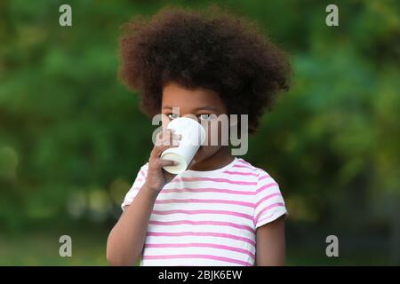 Afroamerikanische Kind Trinkwasser im Freien. Konzept der Wasserknappheit Stockfoto