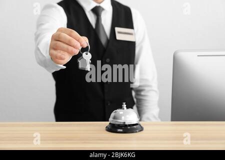 Männliche Mitarbeiter an der Rezeption mit Zimmerschlüssel im Hotel Stockfoto