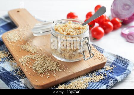 Zusammensetzung mit Quinoa im Glas auf Küchentisch Stockfoto