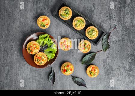 Komposition mit Broccoli Quiche Tartlets auf dem Tisch Stockfoto