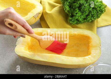 Olivenöl auf die Hälfte der Spaghetti-Kürbis auftragen Stockfoto