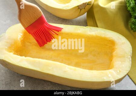 Olivenöl auf die Hälfte der Spaghetti-Kürbis auftragen Stockfoto