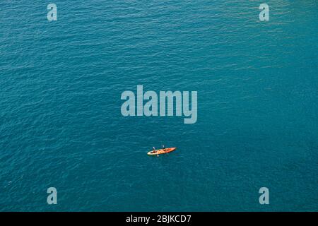 Zwei Personen rudern Ruder in einem gelb-roten Kajak gegen die Beschaffenheit des Meeres. Konzept Banner Reise. Luftaufnahme von oben. Stockfoto