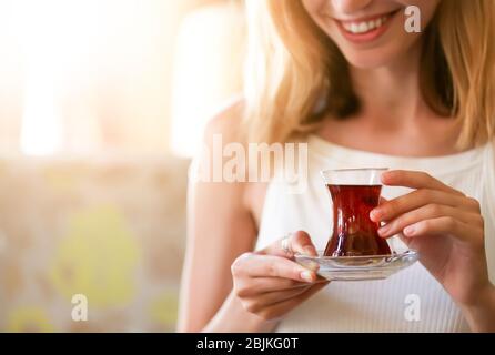 Frau trinkt köstlichen traditionellen türkischen Tee im Café Stockfoto