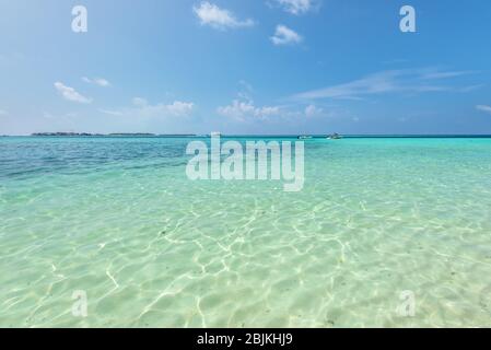 Leere tropischen Strand Hintergrund. Horizont mit resort insel, Himmel und weißen Sand unter klarem Wasser auf den Malediven.