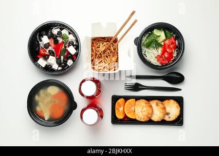 Flacher Lay mit Essen zum Mitnehmen auf weißem Hintergrund. Lieferung von Lebensmitteln Stockfoto