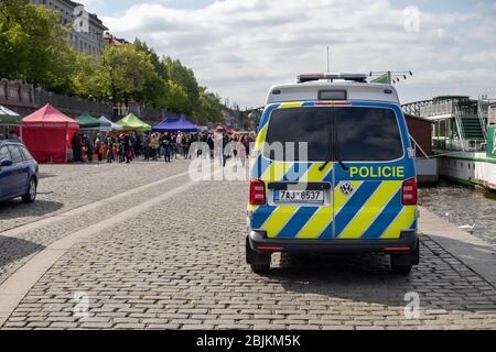 PRAG, TSCHECHISCHE REPUBLIK - 25. APRIL 2020: Polizeiauto auf dem Bauernmarkt in Naplavka, das erste Mal seit dem Ausbruch des Coronavirus wieder eröffnet wurde Stockfoto