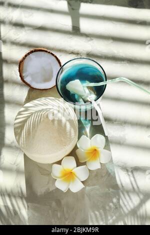 Komposition mit frischer Kokosnuss und einem Glas Cocktail auf dem Tisch Stockfoto