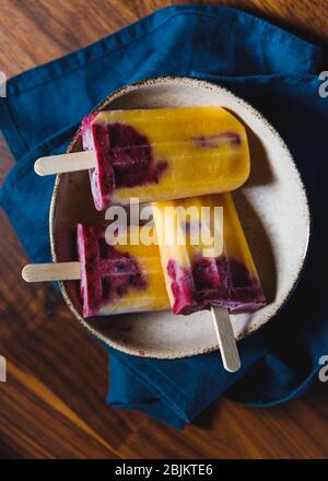 Obst hausgemachte Eis aus frischen Mango, schwarzen Johannisbeeren und Kokosmilch. Gesundes veganes Sommerdessert. Stockfoto