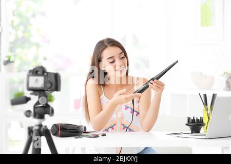 Junge Bloggerin mit Eisenkerne, die zu Hause Video aufzeichnet Stockfoto