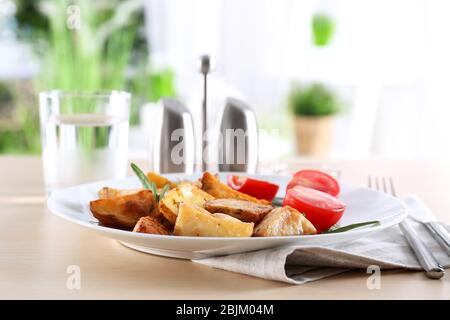 Teller mit leckeren Rosmarinkartoffeln auf dem Tisch Stockfoto