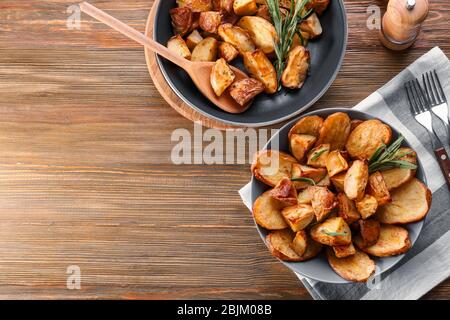 Zusammensetzung mit Teller mit gebackenen Rosmarinkartoffeln auf dem Tisch Stockfoto