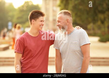 Teenager Junge mit Großvater im Park Stockfoto