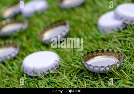 Stapel von abgeworfenen Bierflaschen auf Gras Stockfoto