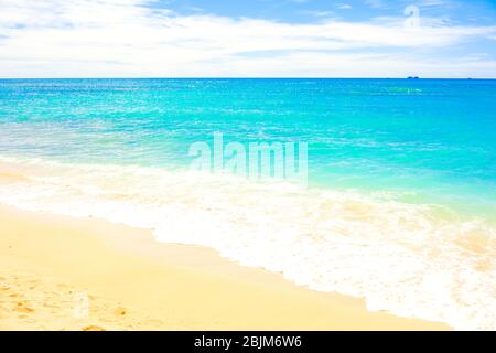 Wunderschöne, klare, blaue Wassermeerwellen mit Meeresblick am warmen Sandstrand Stockfoto