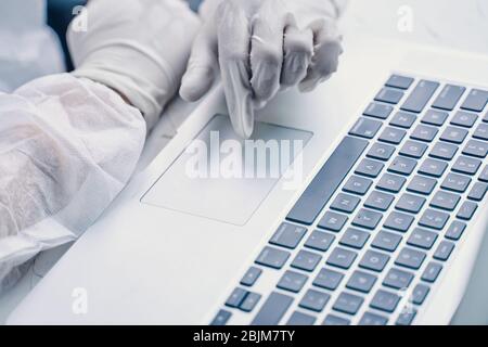 Bio-Gefahr Mann mit Laptop. Geschäftsmann, der in Quarantäne an einem Laptop arbeitet. Stockfoto