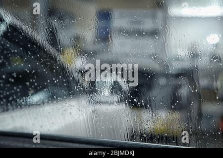 Wassertropfen auf getöntem Autofenster, Nahaufnahme Stockfoto