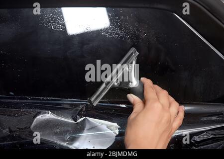 Arbeiterin färben Autofenster Stockfoto