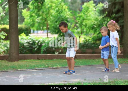 Kleine Kinder spielen hopscotch, im Freien Stockfoto