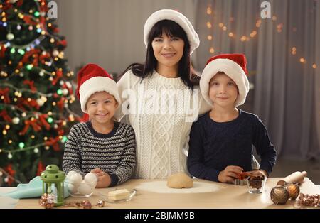 Mutter und kleine Kinder machen Weihnachtskekse in der Küche Stockfoto