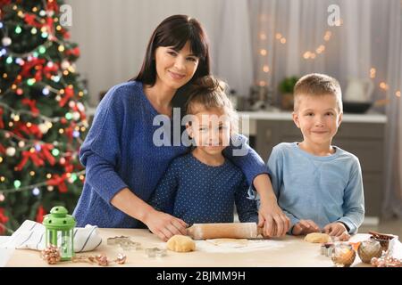 Mutter und kleine Kinder machen Weihnachtskekse in der Küche Stockfoto