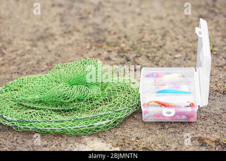 Angelköderbox und Netz am Strand Stockfoto