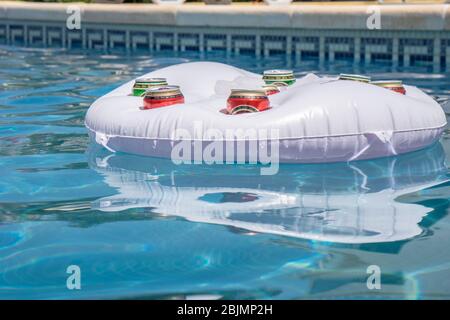 Schwimmbad mit Bierdosen in einer schwimmenden Getränkekühlbox Stockfoto