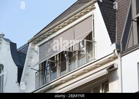 Graue Sonnenschirme an den Fenstern des Dachgeschosses Stockfoto