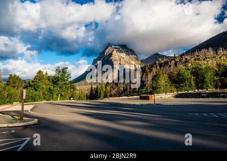 Ein leerer Parkplatz im Glacier National Park, mit schweren Wolken, die den Berggipfel in einem dramatischen frühen Morgenlicht berühren Stockfoto