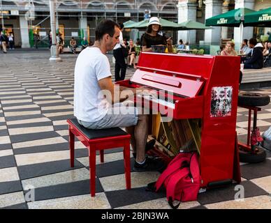 Mann, der ein rotes Klavier spielt, Place Massena, Nizza, Cote d'Azur, Provence, Frankreich. Stockfoto