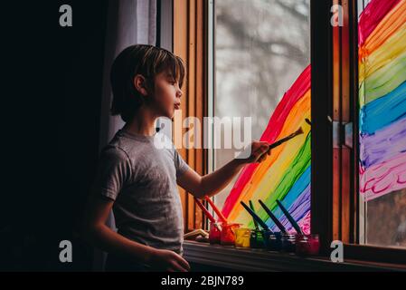 Junge Malerei einen Regenbogen auf einem Fenster, USA Stockfoto