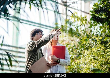 Junge Agraringenieure arbeiten im Gewächshaus Stockfoto