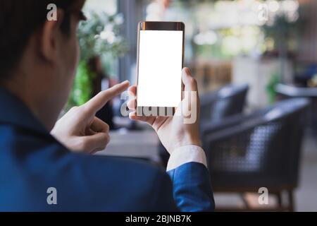 Geschäftsleute halten leere Bildschirm Smartphone im Café. Mockup Smartphone auf männlichen Händen leere Display mit dem Unschärfe-Hintergrund. Stockfoto