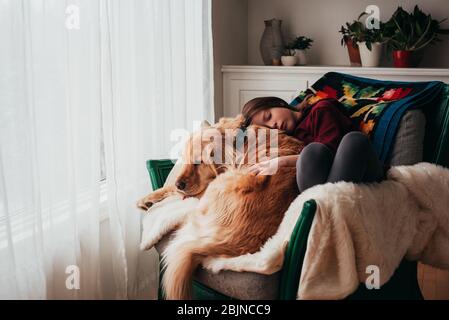 Mädchen schläft auf einem Sofa mit ihrem Hund Stockfoto