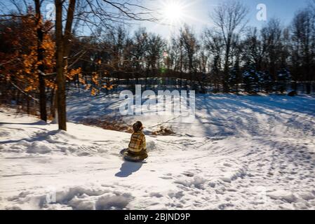 Bub Rodeln einen Hügel im Schnee hinunter, USA Stockfoto