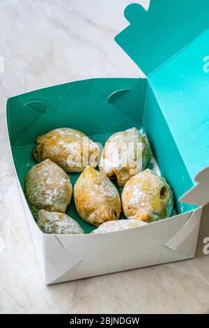 Nehmen Sie traditionelle Acem Cookies mit Walnuss Paste, geriebene Orange und Puderzucker in Box zum Verkauf. Bereit zum Essen. Stockfoto