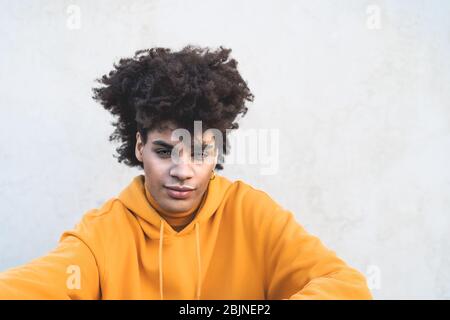 Afro lächelnd Mann Porträt - Gemischte Rasse junger Kerl mit lockigen Haaren posiert vor der Kamera Stockfoto