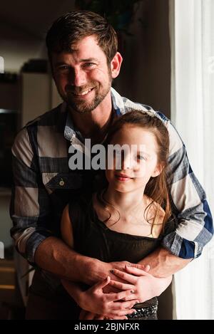 Porträt eines glücklichen Vaters umarmt seine Tochter Stockfoto