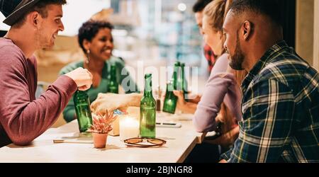 Glückliche Freunde trinken Bier während der Isolation Lockdown - Junge Leute haben Spaß beim Party zu Hause - Fest während Quarantäne Konzept - Fokus auf schwarz Stockfoto