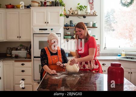 Ältere Frau lehrt ihre Tochter Brot zu machen Stockfoto