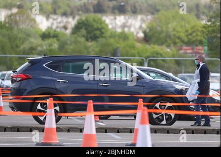 EDS HINWEIS: BILDER DURCH PA-BILDTISCH PIXELIG EIN Mann lenkt den Verkehr in einer Drive-in-Coronavirus-Testanlage bei Ebbsfleet in Kent. Stockfoto