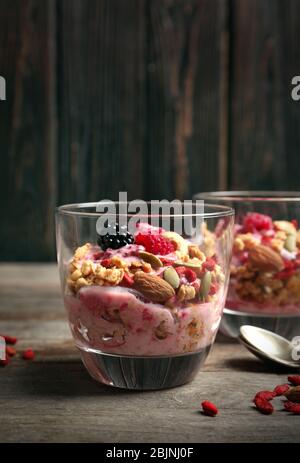 Köstliches Dessert mit Goji Beeren im Glas auf Holzhintergrund Stockfoto