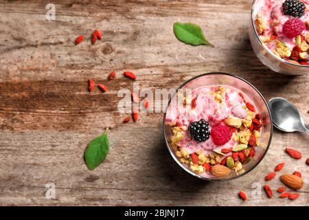 Köstliches Dessert mit Goji Beeren im Glas auf Holzhintergrund Stockfoto