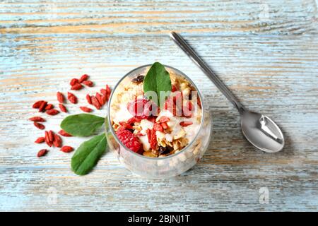 Köstliches Dessert mit Goji Beeren im Glas auf Holzhintergrund Stockfoto