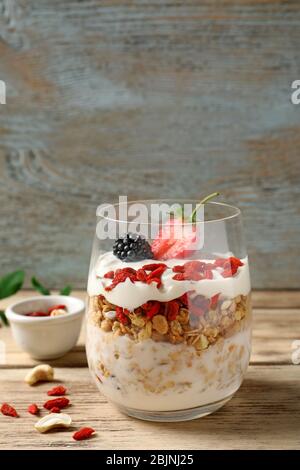 Köstliches Dessert mit Goji Beeren im Glas auf Holzhintergrund Stockfoto