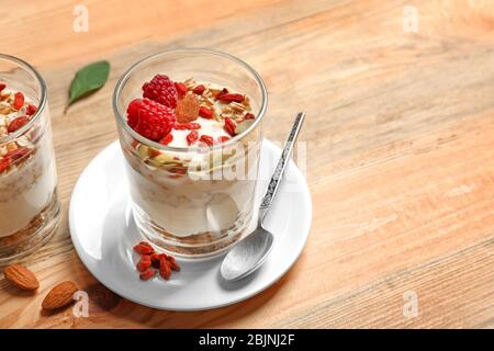 Köstliches Dessert mit Goji Beeren im Glas auf Holzhintergrund Stockfoto