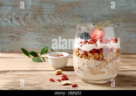 Köstliches Dessert mit Goji Beeren im Glas auf Holzhintergrund Stockfoto