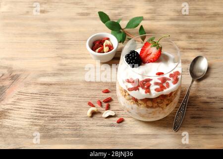 Köstliches Dessert mit Goji Beeren im Glas auf Holzhintergrund Stockfoto